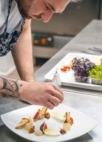 the-chef-is-garnishing-appetizer-dish-PDHYM4B